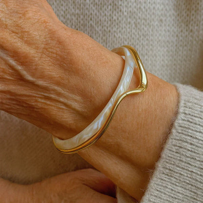Elegante pulsera abierta con esmalte blanco y oro