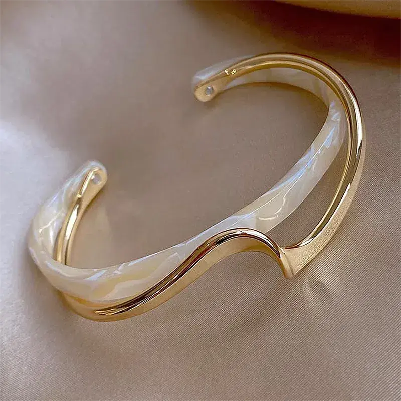 Elegante pulsera abierta con esmalte blanco y oro